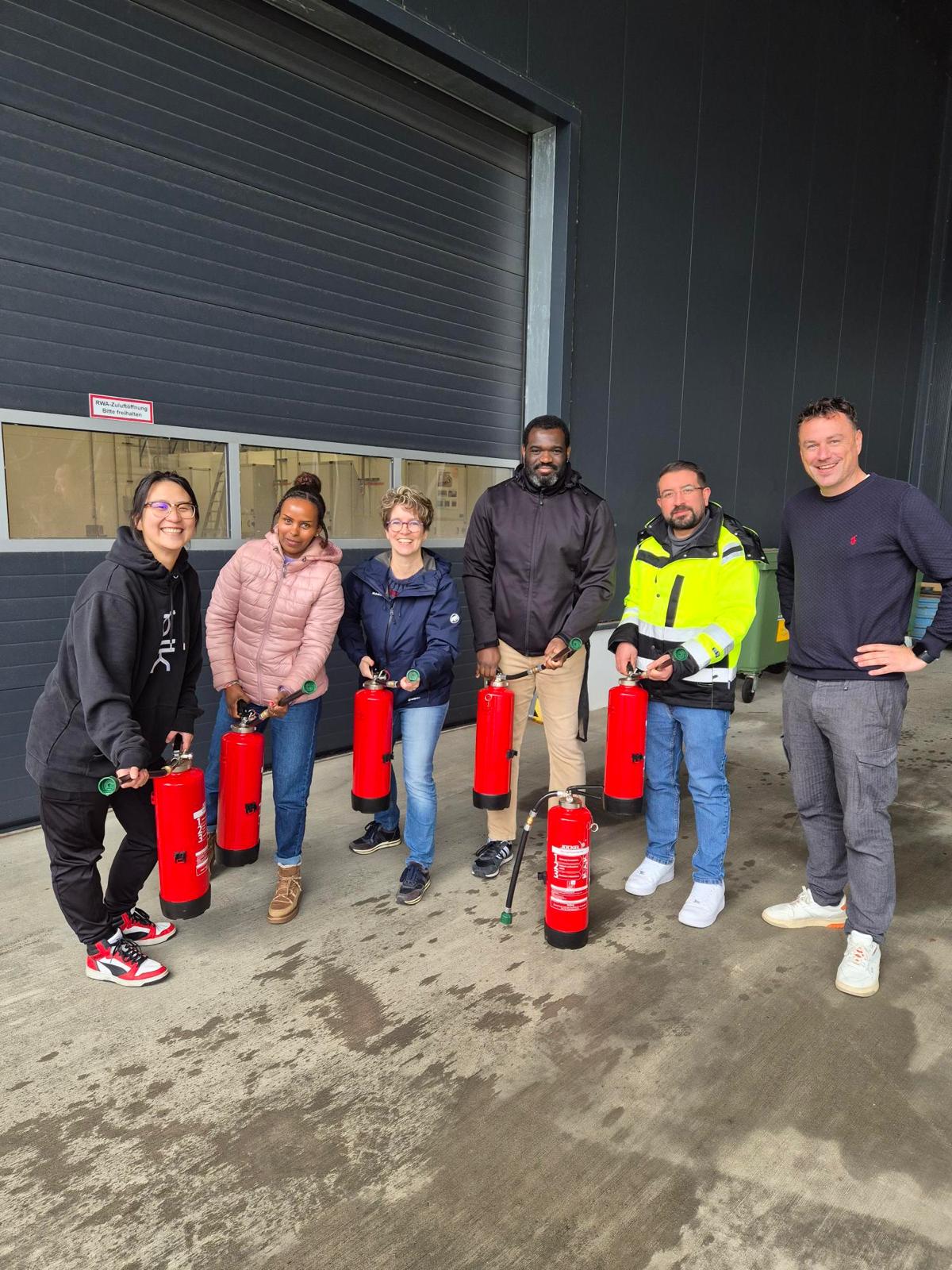 Gruppe mit Feuerlöschern nach der Schulung